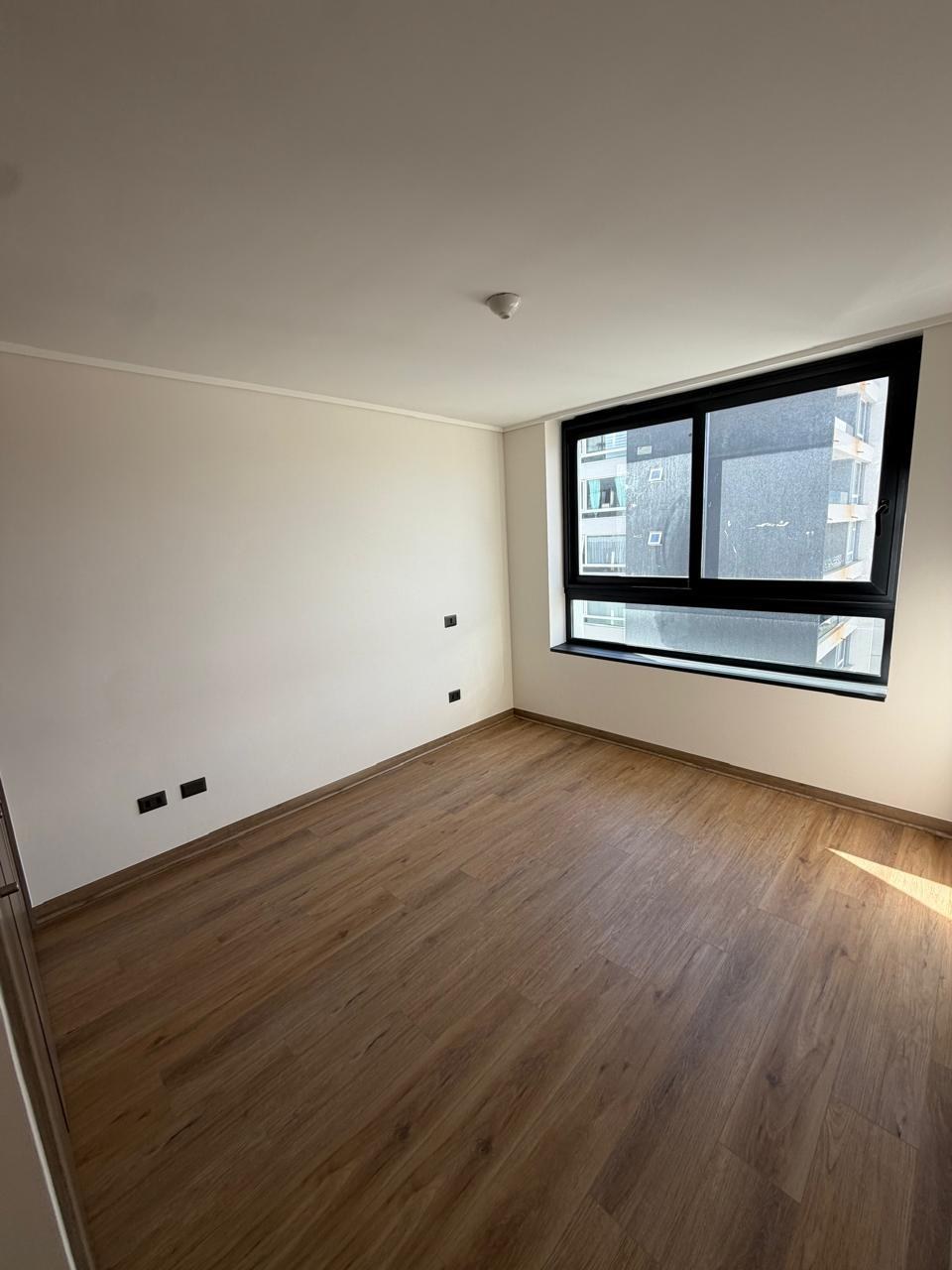 Dormitorio principal vacío con ventana exterior y piso flotante.