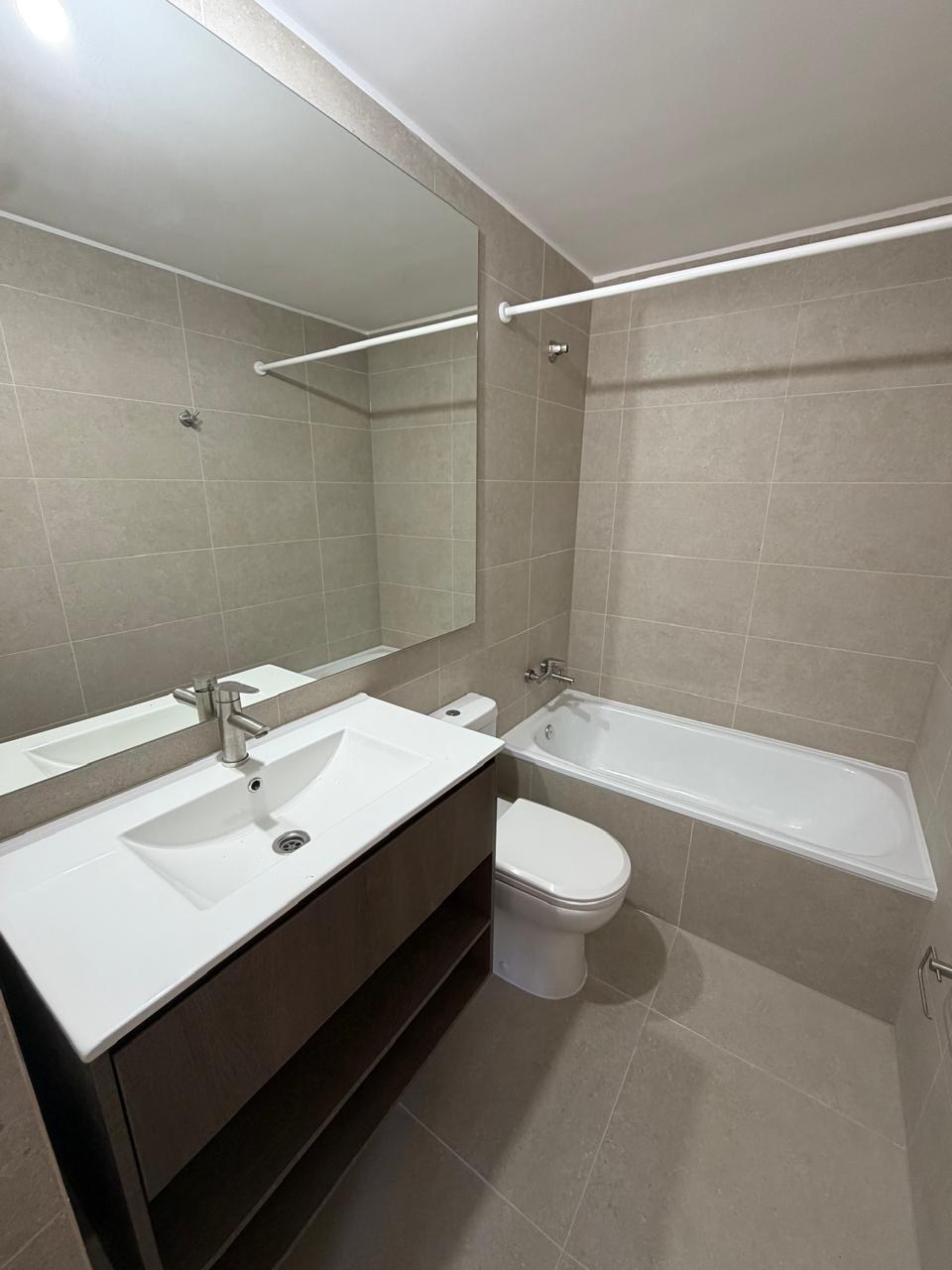 Baño completo con tina, vanitorio moderno y espejo amplio.