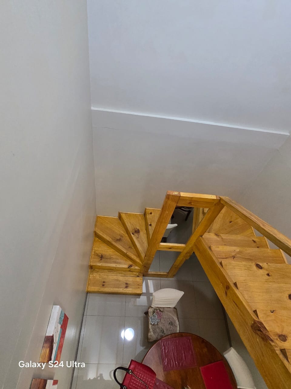 Escalera de madera vista desde el nivel superior.