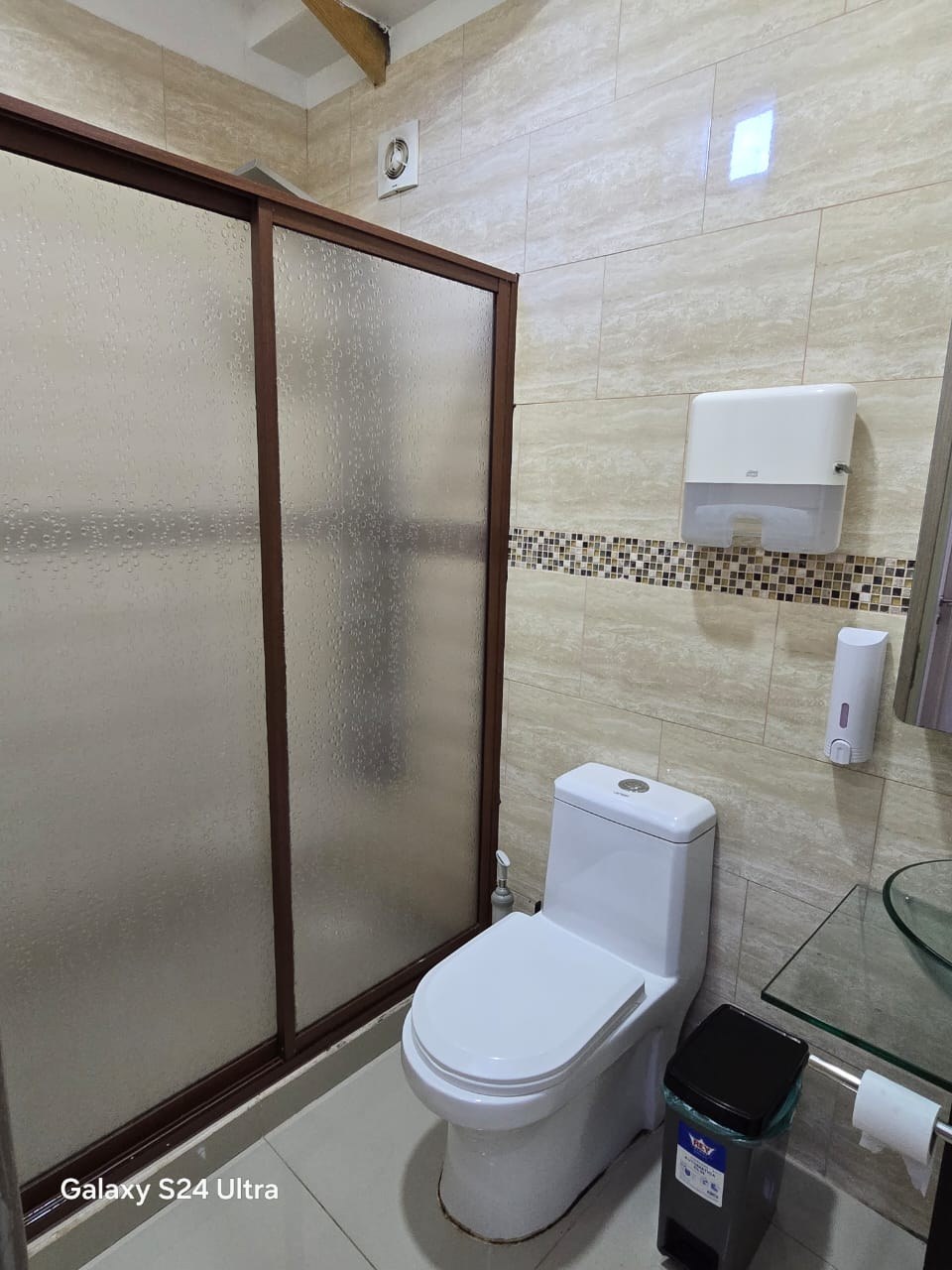 Baño con cabina de ducha shower door e inodoro blanco.