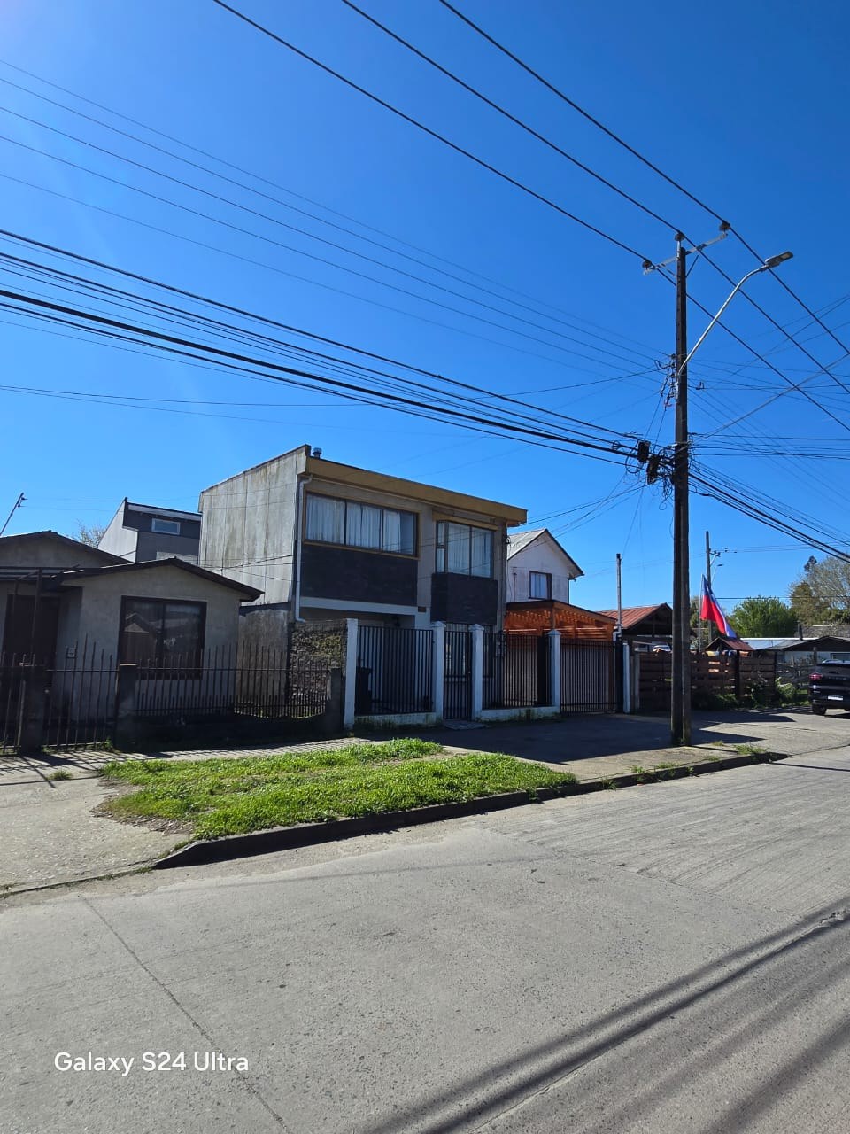Vista frontal amplia de la vivienda desde la calle.