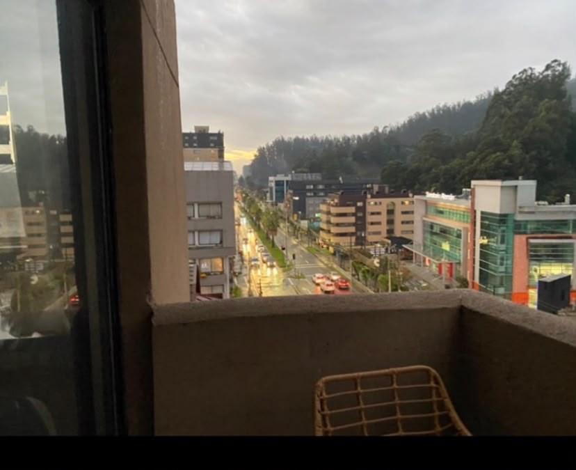 Vista urbana desde balcón hacia avenida y entorno natural
