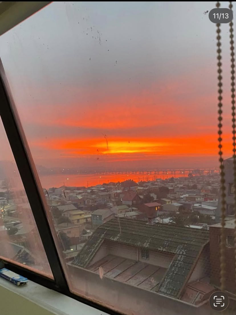 Vista del atardecer sobre la ciudad y el río a través de ventana