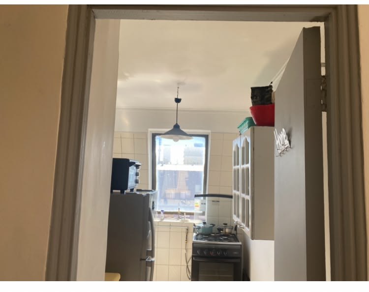 Cocina con refrigerador, cocina a gas, muebles y ventana