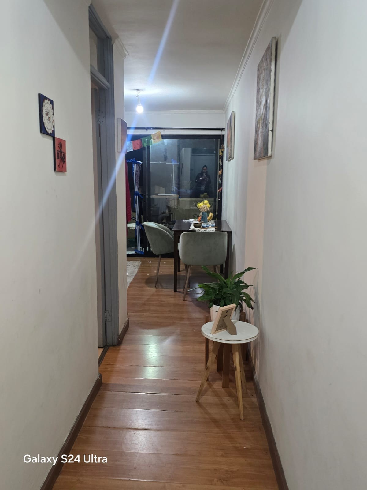 Comedor visto desde pasillo con mesa y sillas tapizadas