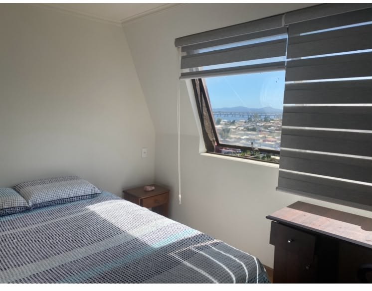 Dormitorio con cama de dos plazas y ventana con vista abierta