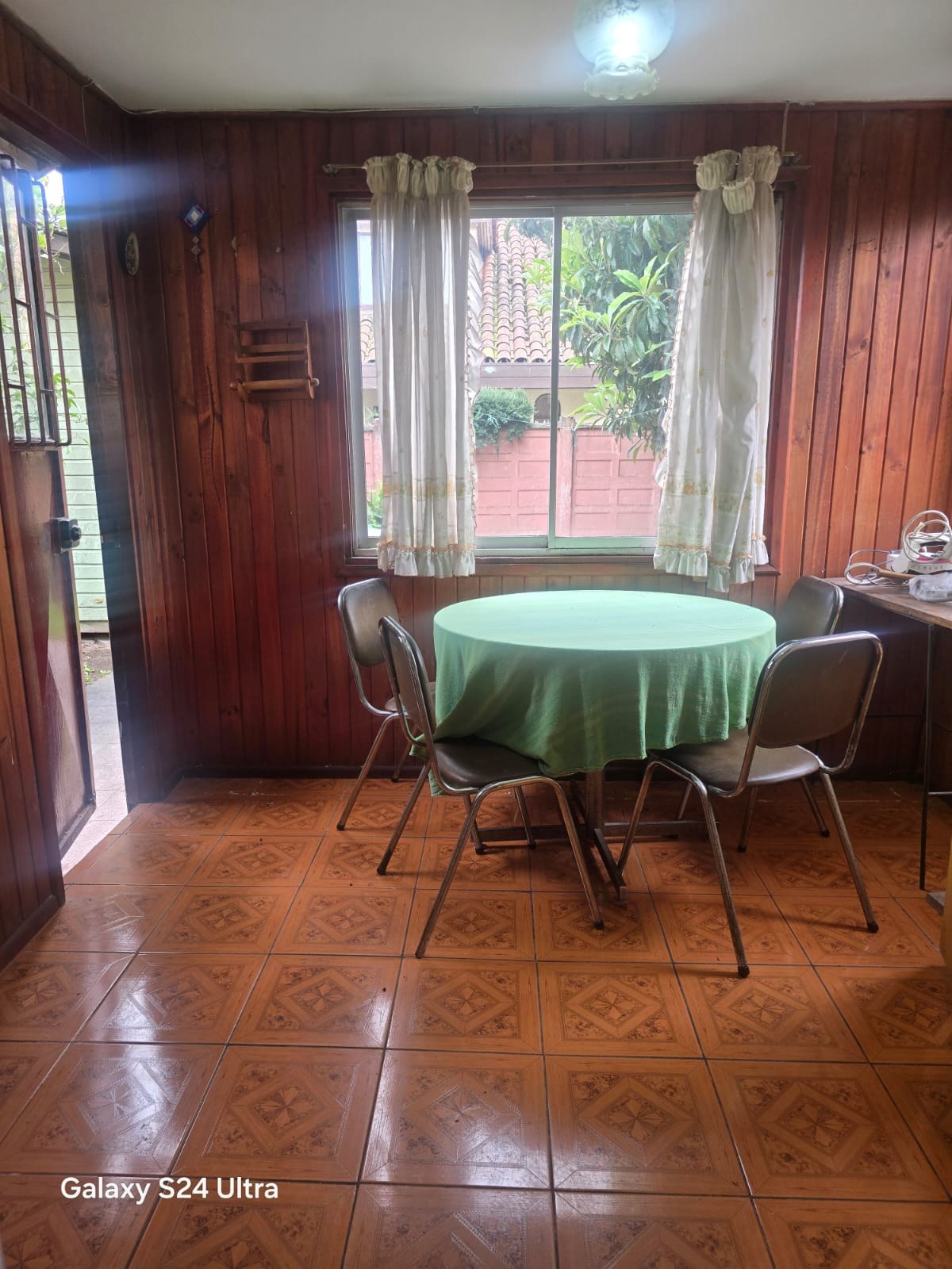 Comedor de diario revestido en madera con ventana al jardín
