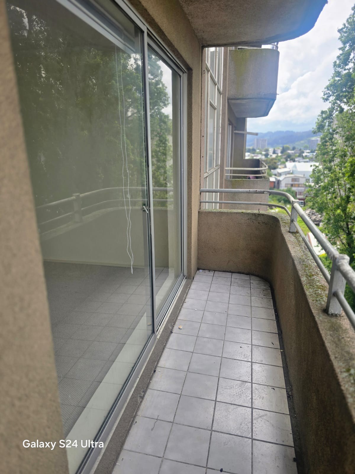 Balcón con piso cerámico, ventanal corredizo y vista exterior