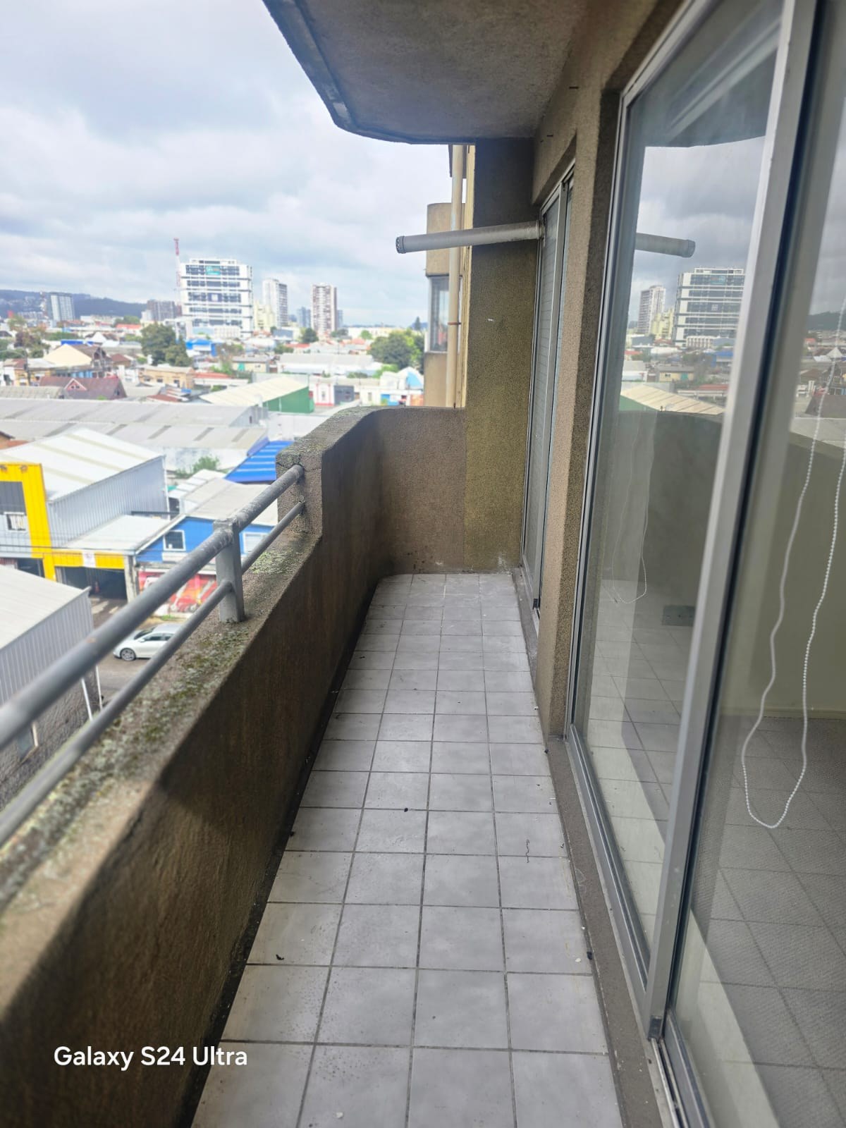 Terraza balcón alargada con baranda y vista despejada a la ciudad