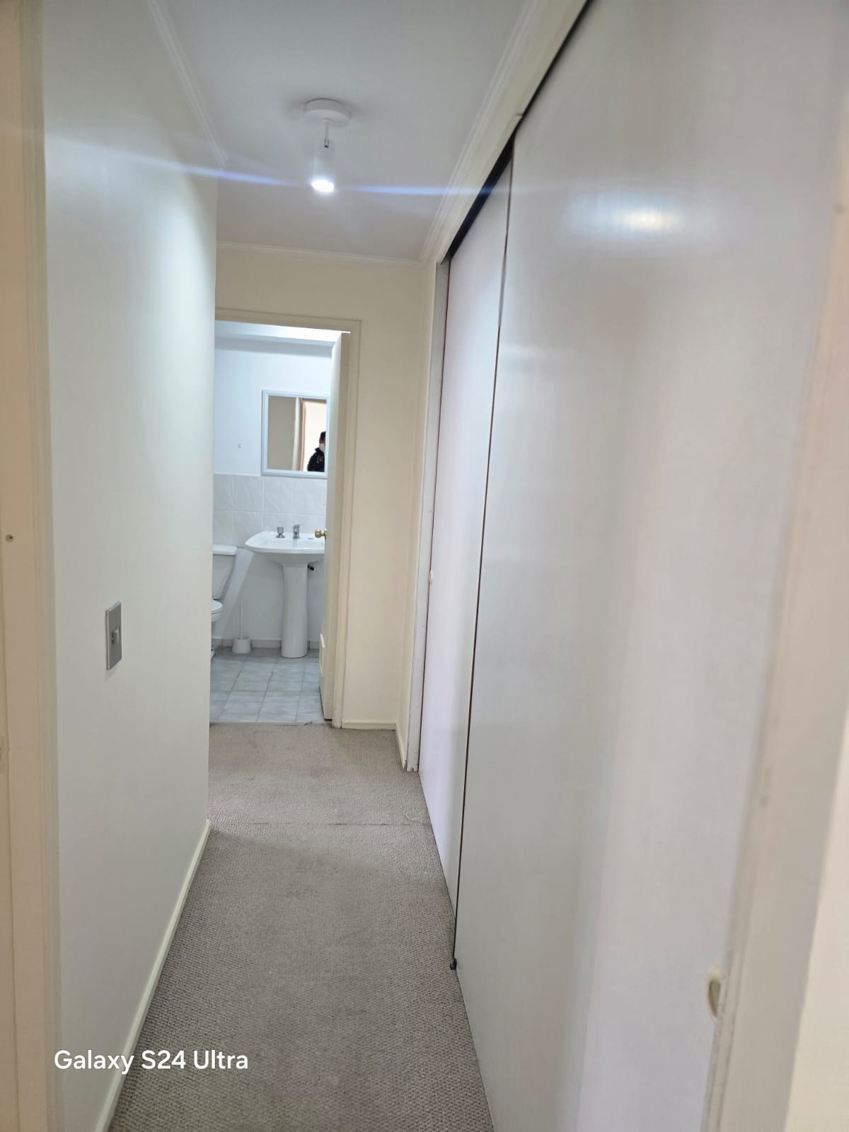 Pasillo con clósets de puertas correderas hacia el baño