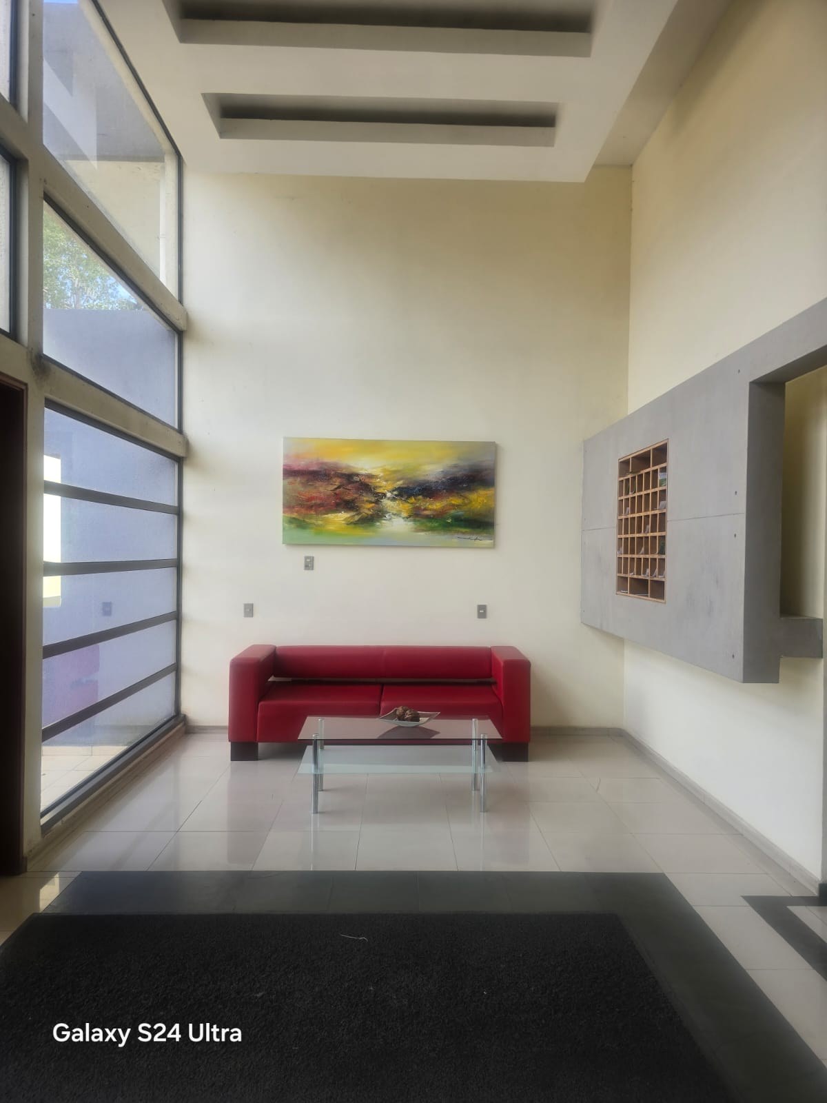 Hall de acceso con sala de estar y cuadro decorativo