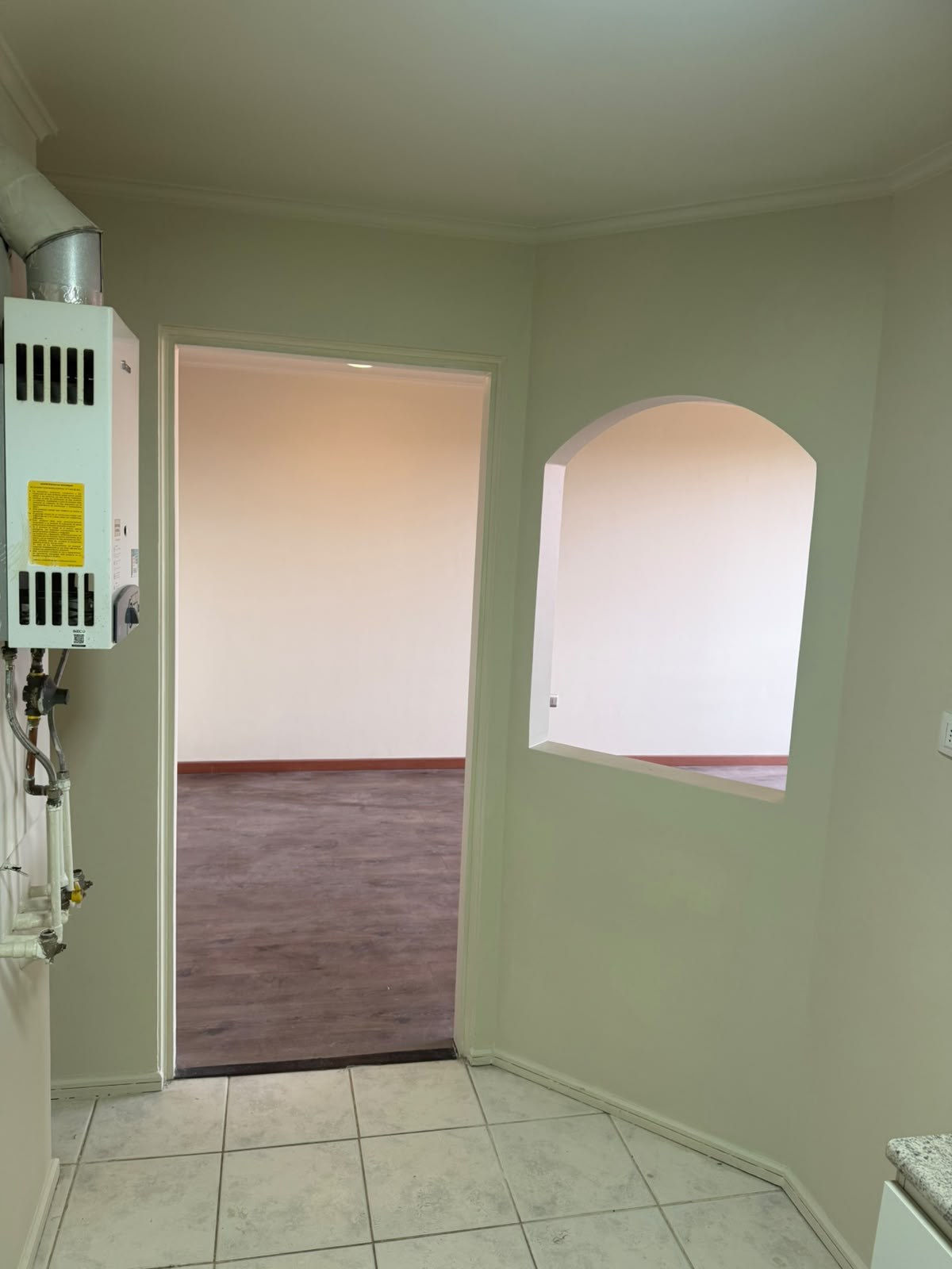 Vista hacia la sala desde la cocina con vano pasaplatos