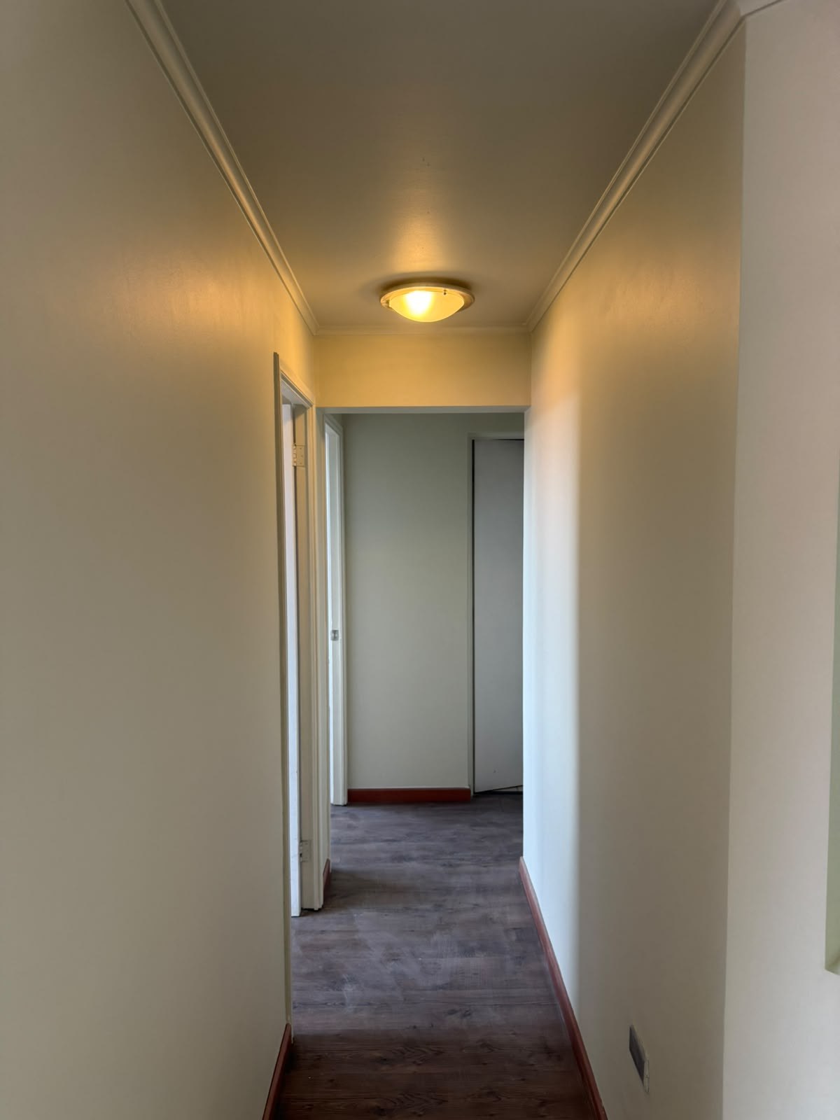 Pasillo de distribución hacia las habitaciones con lámpara de techo