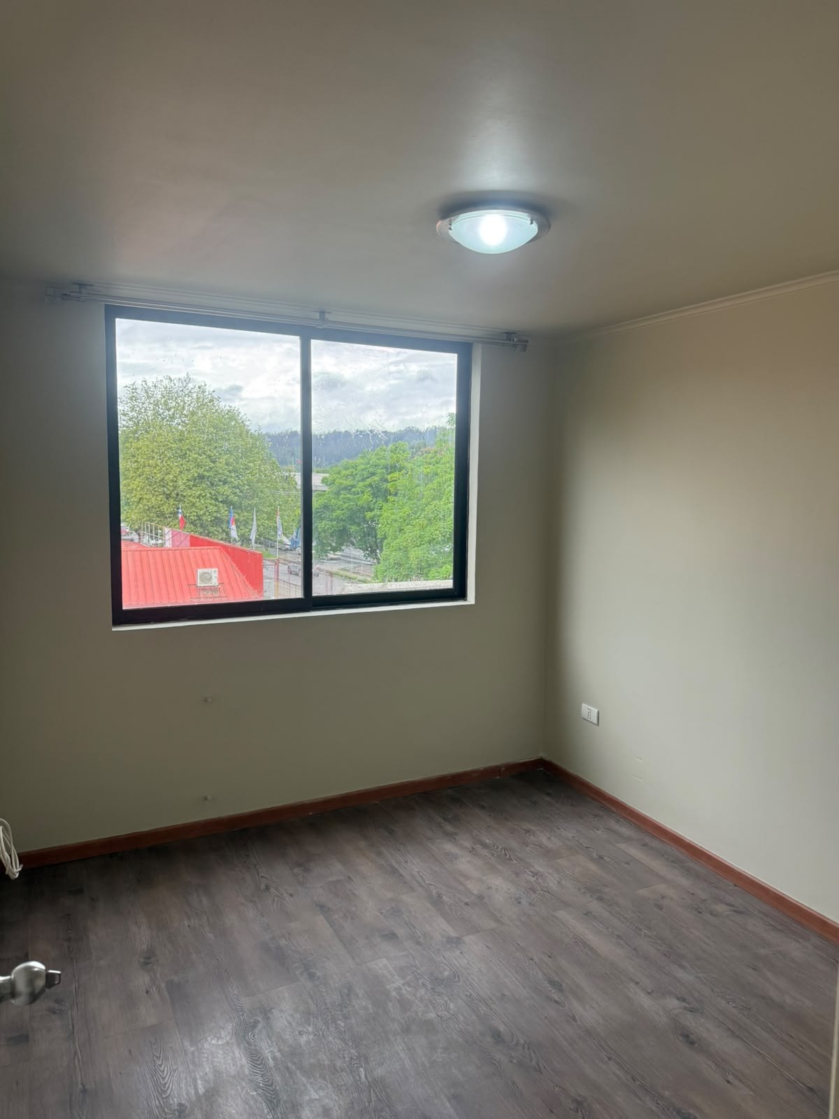 Dormitorio luminoso con gran ventana al exterior y piso flotante