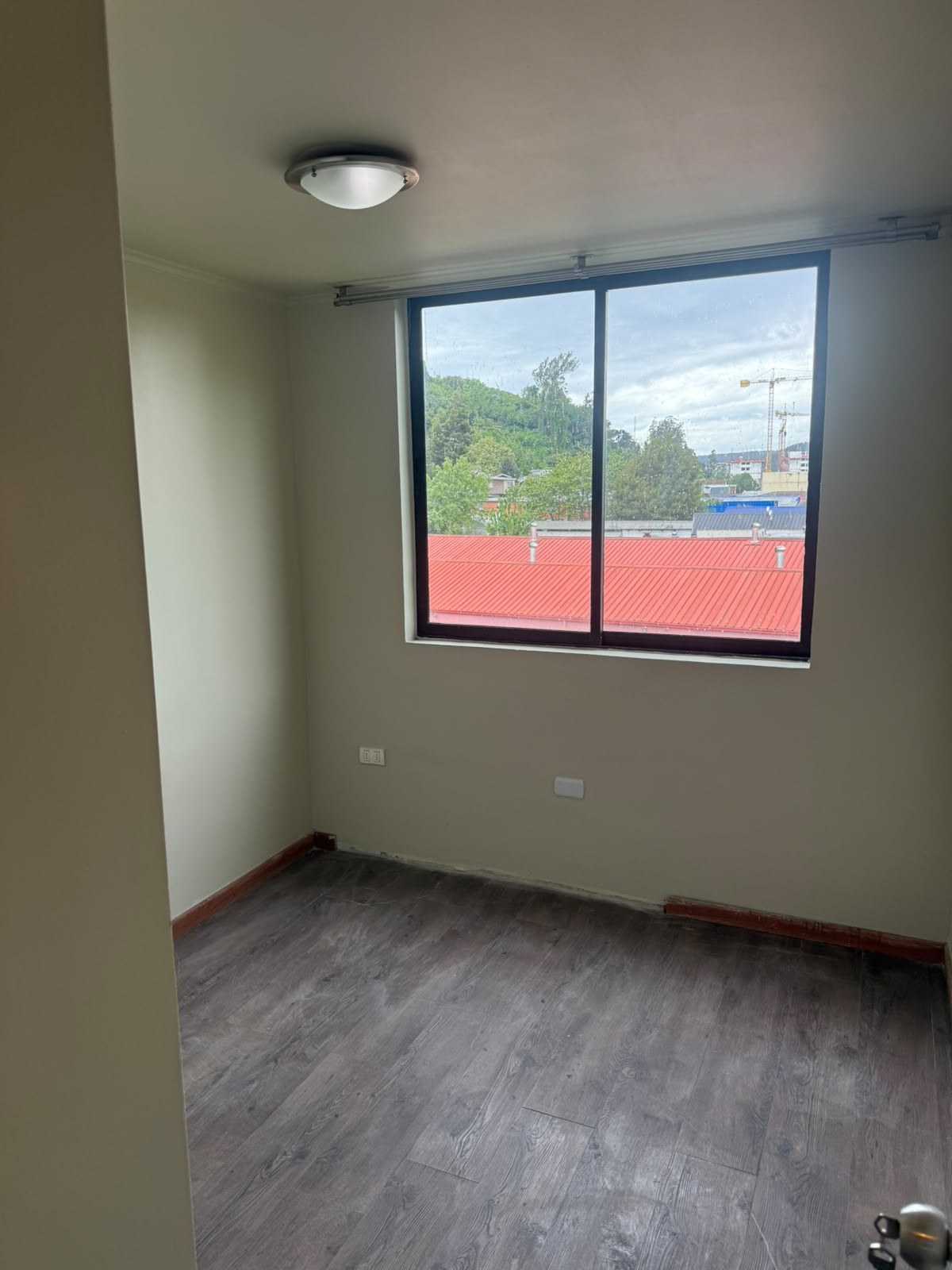 Segundo dormitorio con piso flotante y ventana con vista exterior