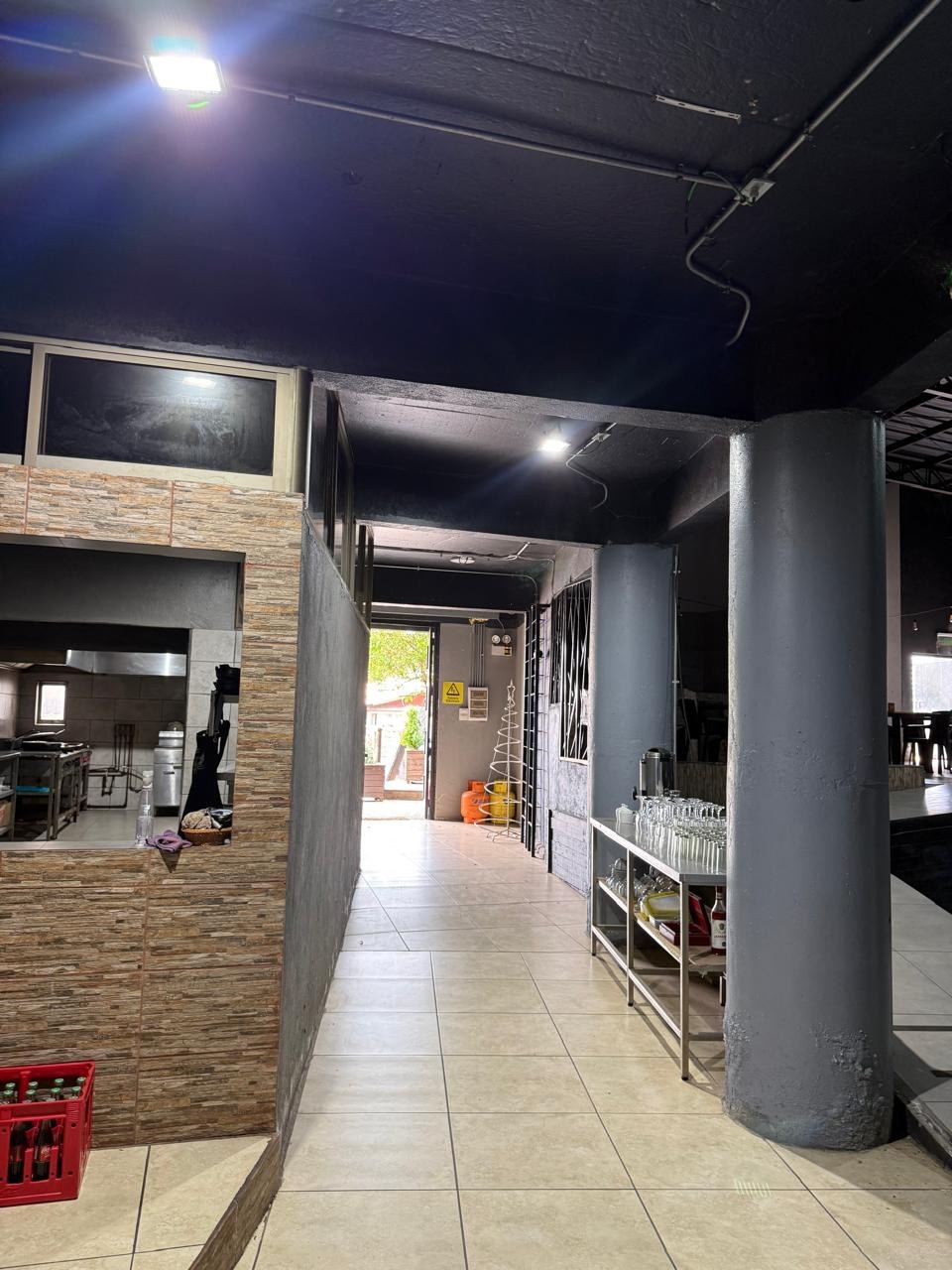 Sector de cocina y barra de servicio con pasillo de atención